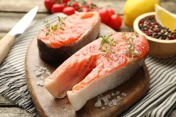 Seafood. Salmon steaks, spices, tomatoes and lemons on table, closeup