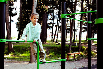 Obraz premium little cute girl having fun on training playground outside