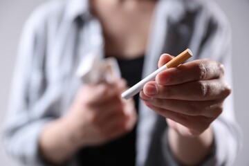 Woman with cigarette on light background, closeup. Smoking