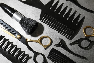 Different hairdresser's tools on grey table, flat lay