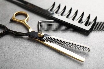 Different hairdresser's tools on grey table, closeup