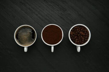 Aromatic ground coffee, beans and hot drink on black table, flat lay