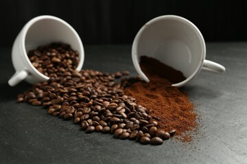 Aromatic ground coffee and beans on black table, closeup
