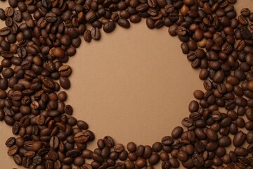 Frame of aromatic coffee beans on beige background, flat lay. Space for text