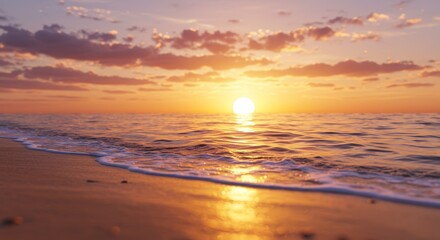 Obraz premium Golden Sunset Ocean Beach - Serene sunset over calm ocean waves gently lapping on a sandy beach. Warm golden light illuminates the scene