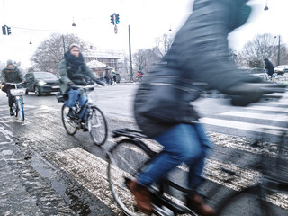 Copenhagen - People commute in Copenhagen during the winter day. Snow, slush on a road. Dangerous slippery conditions.