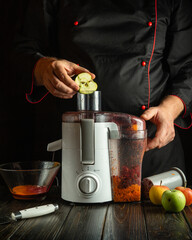 A skilled chef is preparing a fresh juice by placing slices of apple into a juicer. The warm...