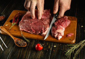 Hands skillfully cut raw meat on a wooden board surrounded by fresh spices and herbs, creating an inviting atmosphere in a traditional kitchen