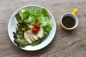 grilled  slice chicken breast with vegetable salad on plate dressing Japanese sesame oil soy sauce