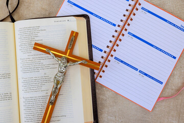 24 April 2025 Washington DC US Crucifix rests on an open Holy Bible while planner is nearby on...