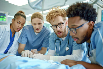 Obraz premium Medical students stitch artificial skin model, focusing on precision under intense surgical lighting