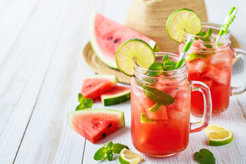 Refreshing watermelon drinks served in mason jars with lime and mint on a sunny summer day
