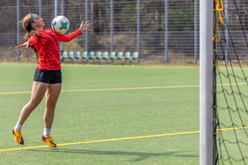 Girl on the soccer field. Soccer training. Active lifestyle. Football concept.