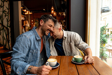 Two men sharing affection and enjoying a delightful coffee break together at a cozy cafe, radiating...