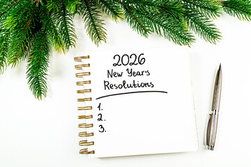 New year resolutions 2026 on desk. 2026 goals list with notebook, christmas tree on white background. Resolutions, plan, goals, action, checklist, idea concept. New Year 2026 resolutions, copy space