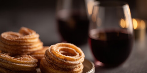 Fototapeta premium Crispy churros with red wine on romantic candlelit table