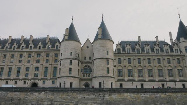 Riverboat cruise on the Seine. View of the majestic medieval Conciergerie Palace, a former courthouse and prison in Paris, France, located on the western side of the Island Cite (Ile de la Cite).