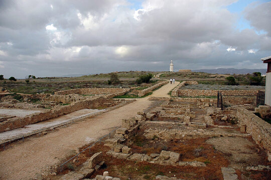 Casa di Dioniso: rovine archeologiche di Paphos, Cipro: sentiero tra antiche mura che conduce al faro sotto cieli nuvolosi