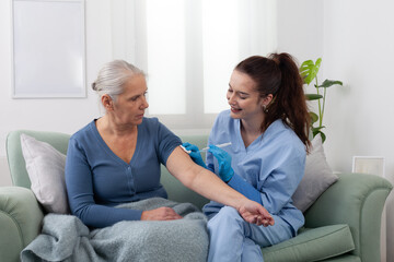 Nurse or doctor holding syringe, preparing injection of vaccine or medication for elderly patient at home or clinic. Medical care, treatment, and prevention concept