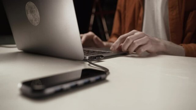 Close-up of male hand unplug multiport station for laptop. multiple different ports in usb hub.