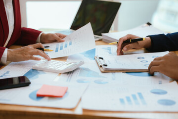 A professional businesswoman collaborates with colleagues in a corporate meeting, analyzing financial charts, discussing strategy, planning growth, and presenting results.