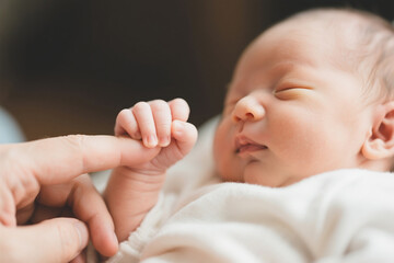 신생아 아기 손 클로즈업. 엄마의 손을 잡고 있다