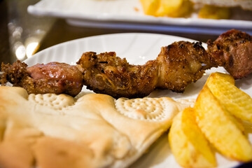 Plate with grilled skewer, potatoes and Uzbek bread in a restaurant in Khiva (Uzbekistan)