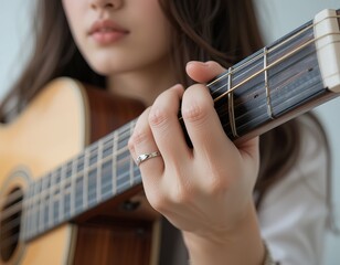 Fototapeta premium Melody in Focus – Close-Up of a Girl Playing Acoustic Guitar