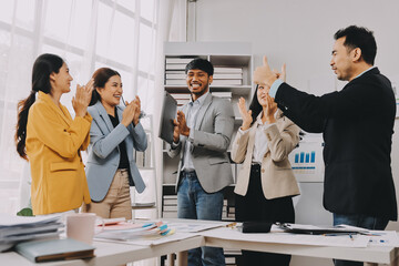 Group of Young Asian business team creative businesspeople coworker in office Happy to be successful partnership teamwork celebrating achievement and success concept.