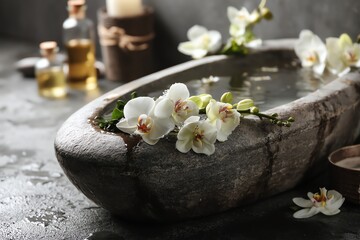Spa setting with stone bowl and white orchids.