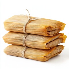 Stack of three tamales wrapped in corn husks on white background