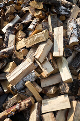 Stack of birch firewood with hand chopping block. Chopped firewood for winter. Lot of firewood - harvesting wood for heating the house. Horizontal photo. Chopped firewood background and texture 16x9.