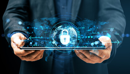 Fototapeta premium Businessman holding digital tablet with glowing cybersecurity lock interface over dark background representing data protection concept.