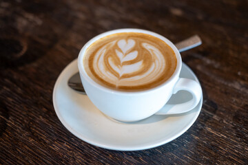 A cup of coffee with latte art, on the table