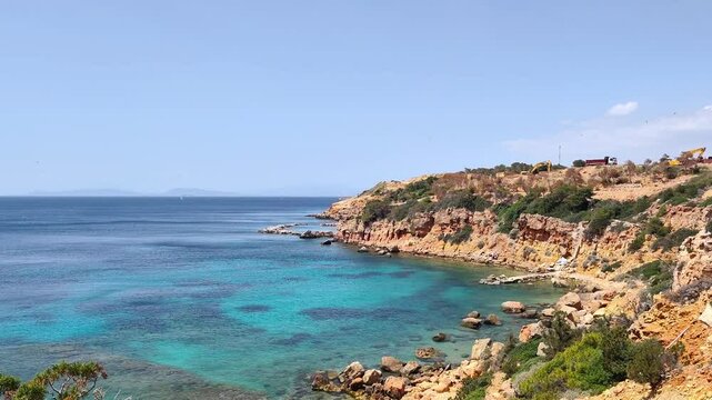 Stunning coastal view of Lemos, Vouliagmeni in Attica, Greece, featuring crystal-clear waters, rugged cliffs, lush greenery, and a serene Mediterranean atmosphere.