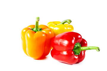 Fresh juicy shiny red, yellow and orange bell peppers. Isolated on white.