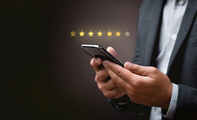 A businessman using his smartphone to count stars and rate in an online customer review form, star