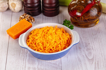 Yellow shredded cheddar cheese in the bowl