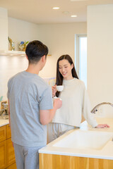 Fototapeta premium 夫婦がキッチンでコーヒーを楽しみながら朝の時間を共に過ごす穏やかなシーン