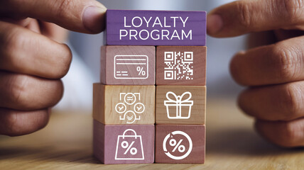 Wooden blocks stacked, showcasing loyalty program concept with icons: credit card, QR code, gift, shopping bag, percentage symbols, symbolizing rewards and customer retention