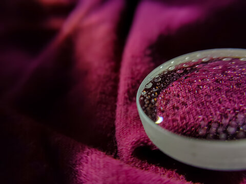 Fototapeta close up of a convex lens with water droplets on an insulated cloth