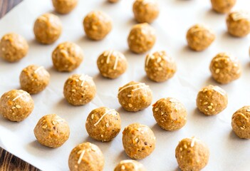 A white plate topped with lots of peanut butter balls.