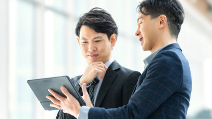 タブレットを使って打ち合わせをする2人の男性ビジネスマン