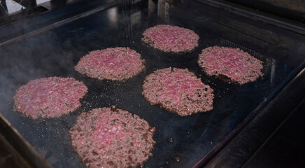 Smash burger patties sizzling on the griddle