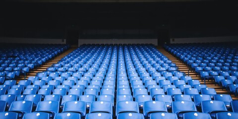Rows of empty blue stadium seats awaiting an audience