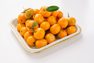 Stack of Mandarin oranges in a square tray on a white table