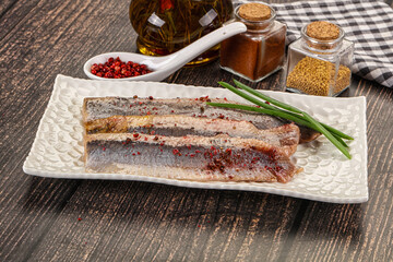 Salted marinated herring fillet with spices