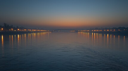 Fototapeta premium Calm river at twilight, city lights reflected