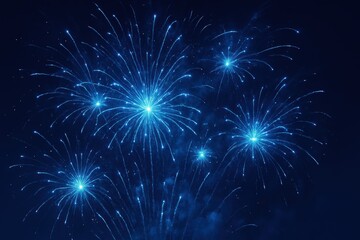 Fototapeta premium Brilliant blue fireworks exploding across a deep night sky, glowing bursts captured in mid-air for use in festive, patriotic, or New Year celebration designs and seasonal promotional materials.