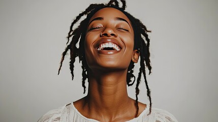 A profile view of a smiling Black woman with curly, shoulder-length hair adorned with earbuds.